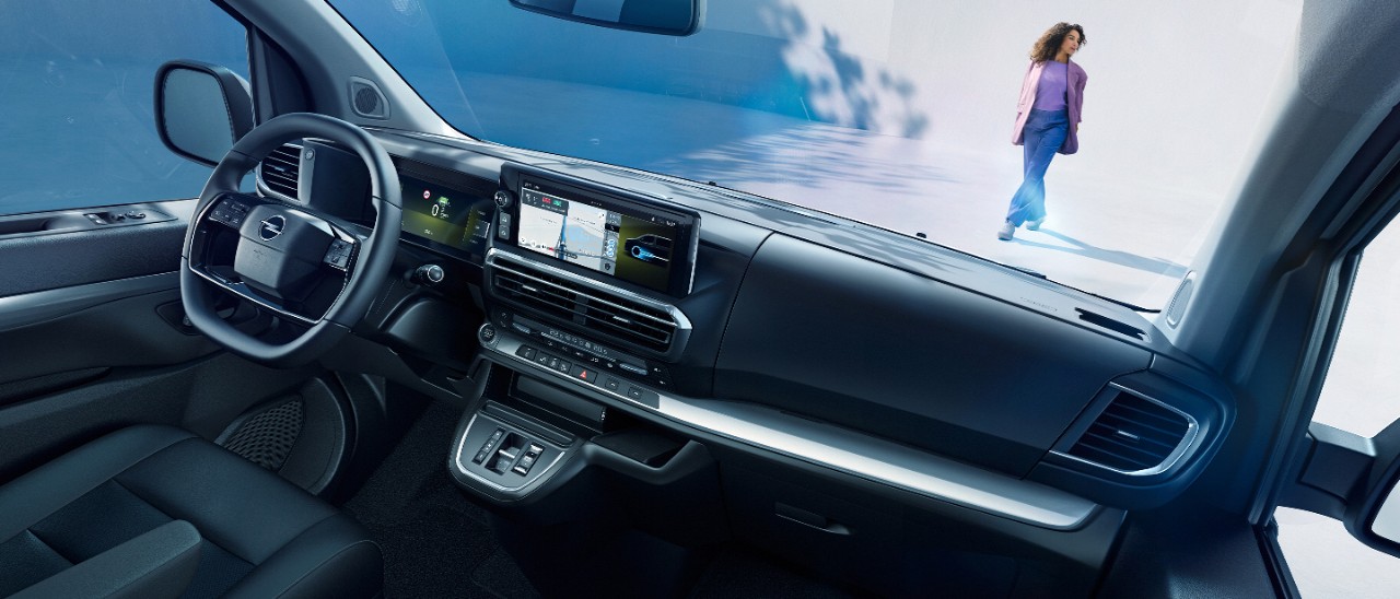  Unutrašnji pogled na bijelu Opel Zafiru Electric sa suvozačevog sjedala sa ženom koja stoji vani